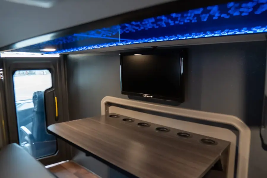 Sala VIP do Double Deck G8, com mesa e TV