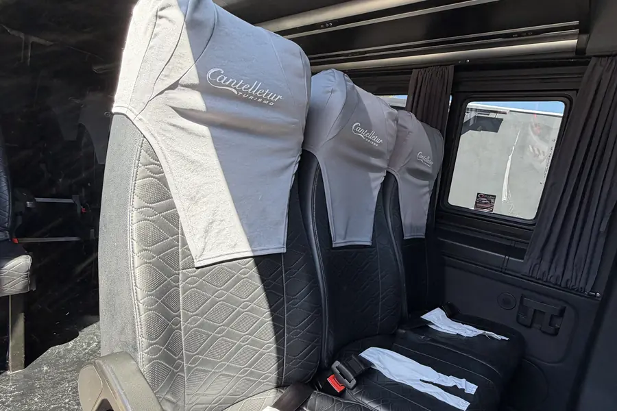 Poltronas da Van junto à janela, com cortina e cinto de segurança